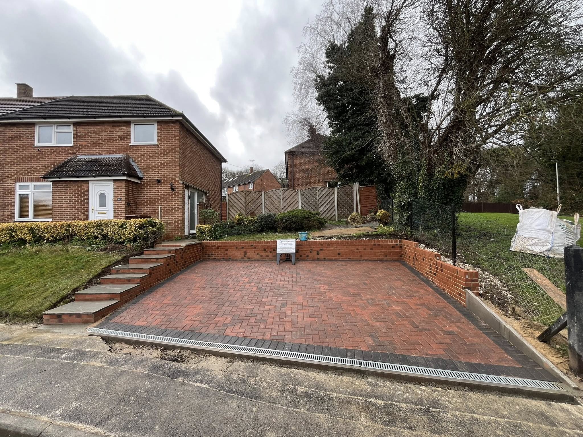 Wide angle view of completed Brett omega block paving driveway with retaining walls and sandstone steps Maidstone