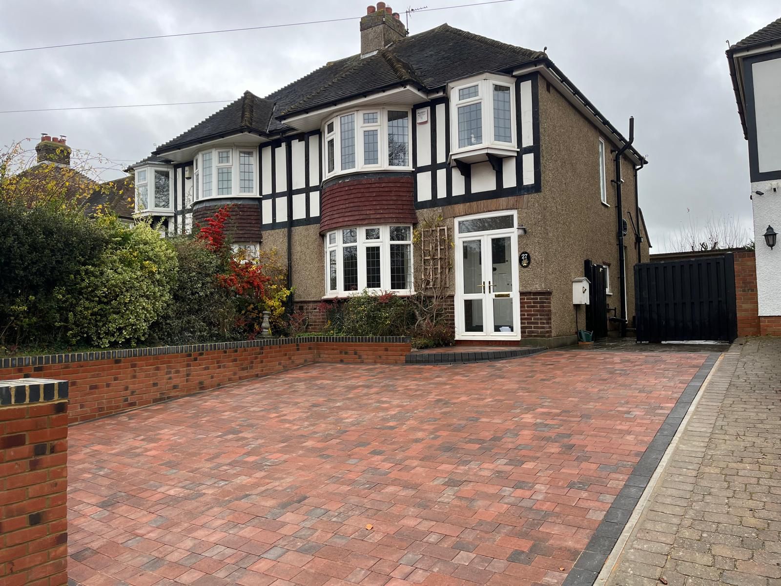Red brick driveway with black border edging and retaining wall Rochester